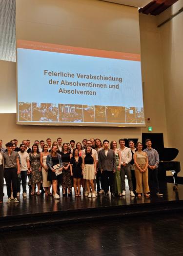 Absolventen und Absolventinnen auf einer Bühne