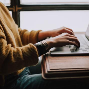 Person an Laptop sitzend